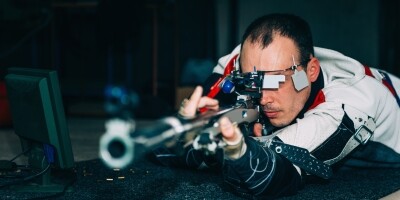 Grafika przedstawia mężczyznę strzelającego z długiej broni